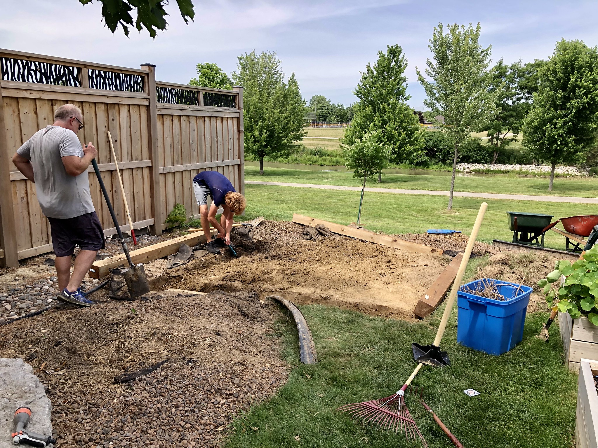 Digging a foundation for a polycarbonate backyard greenhouse kit.